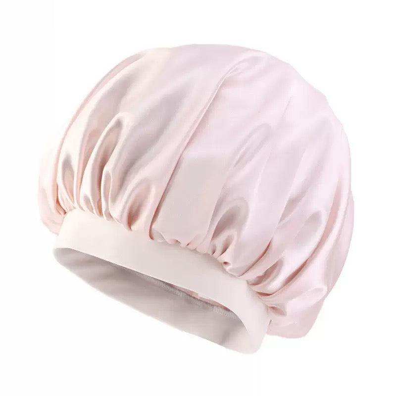 Pink Bonnet Cap in pale pink, with a smooth satin-like finish, gathered crown and wide cream elastic band.