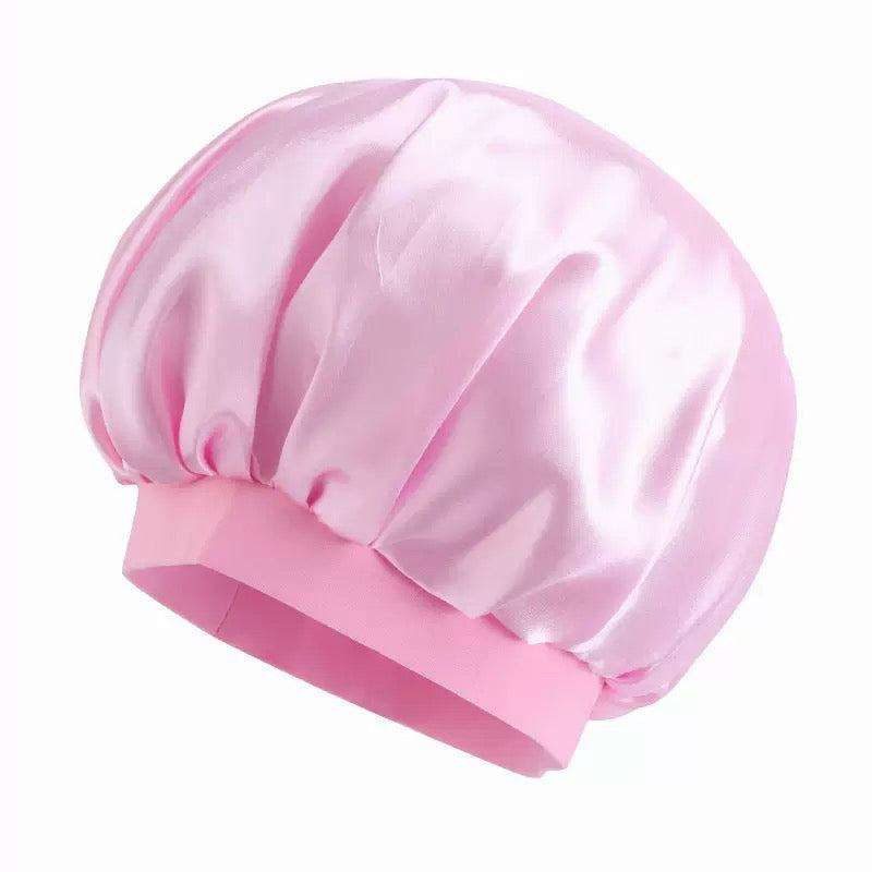Pink Bonnet Cap in shiny smooth fabric with gathered panels and a wide elastic band around the opening.