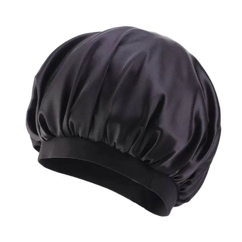 Pink Bonnet Cap in glossy black smooth fabric, with a gathered crown and wide elastic band.