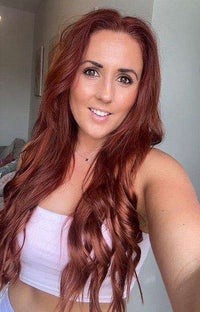 Premium Halo Hair Extensions in long, wavy spiced auburn hair with a rich reddish-brown tone and natural finish